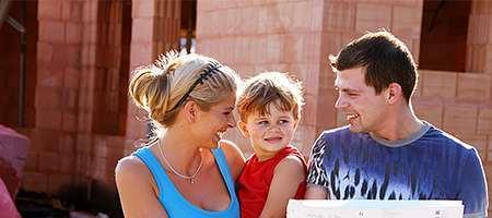 Familie vor Neubau ohne Fenster